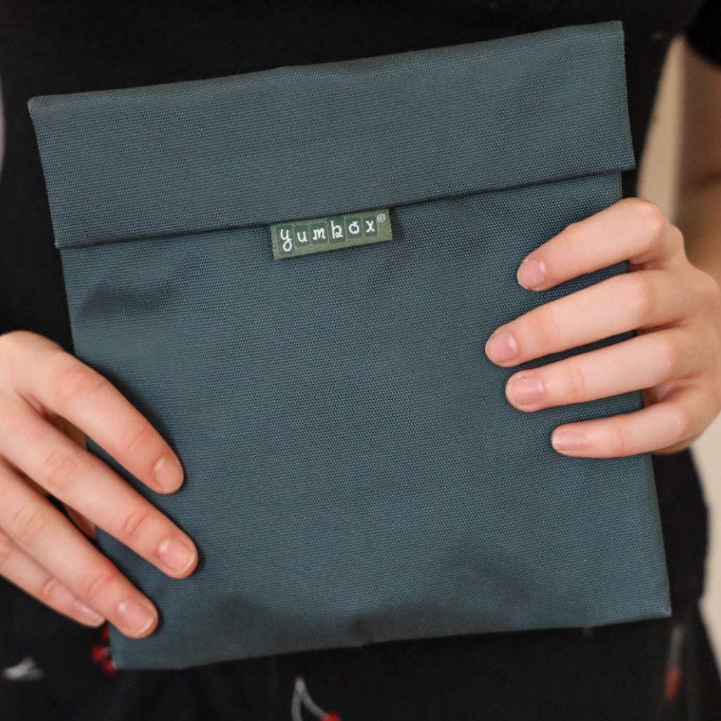 Woman holding reusable sandwich/snack bag in fern green color