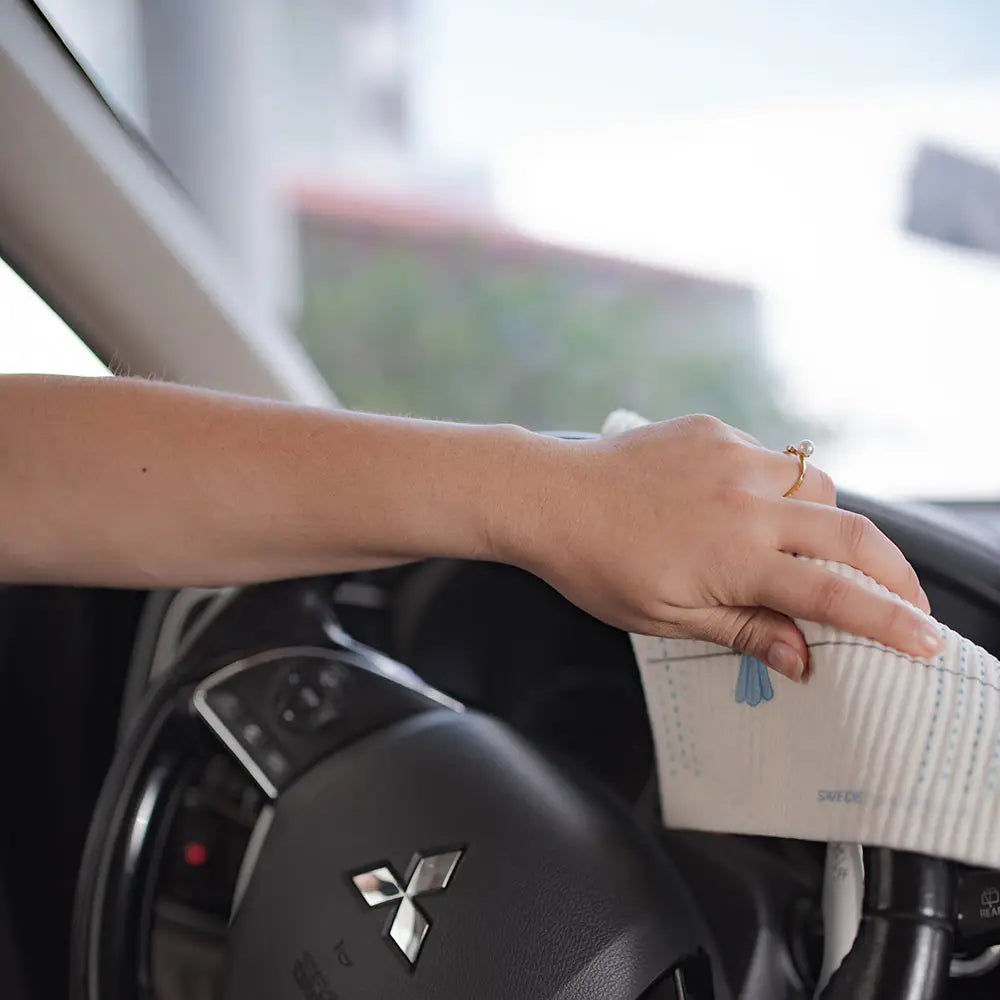 Steering wheel of car being cleaned with Swedish dish cloth