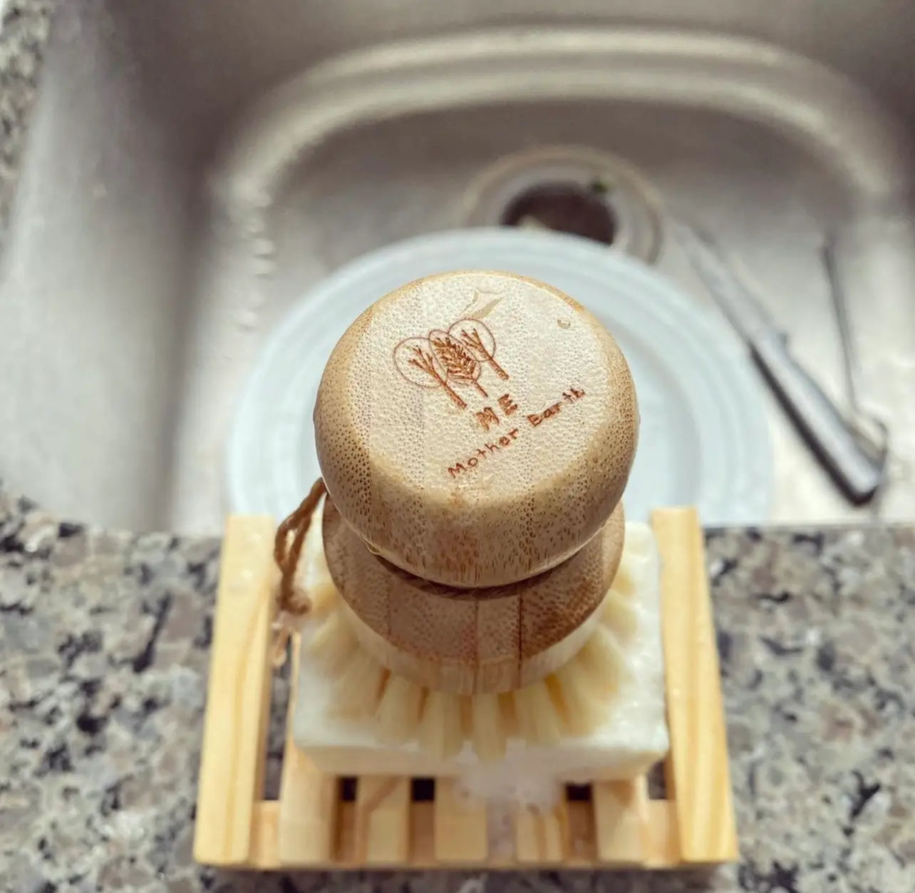 Woman holding ergonomic Sisal Brush with dish soap and elevated bamboo soap tray