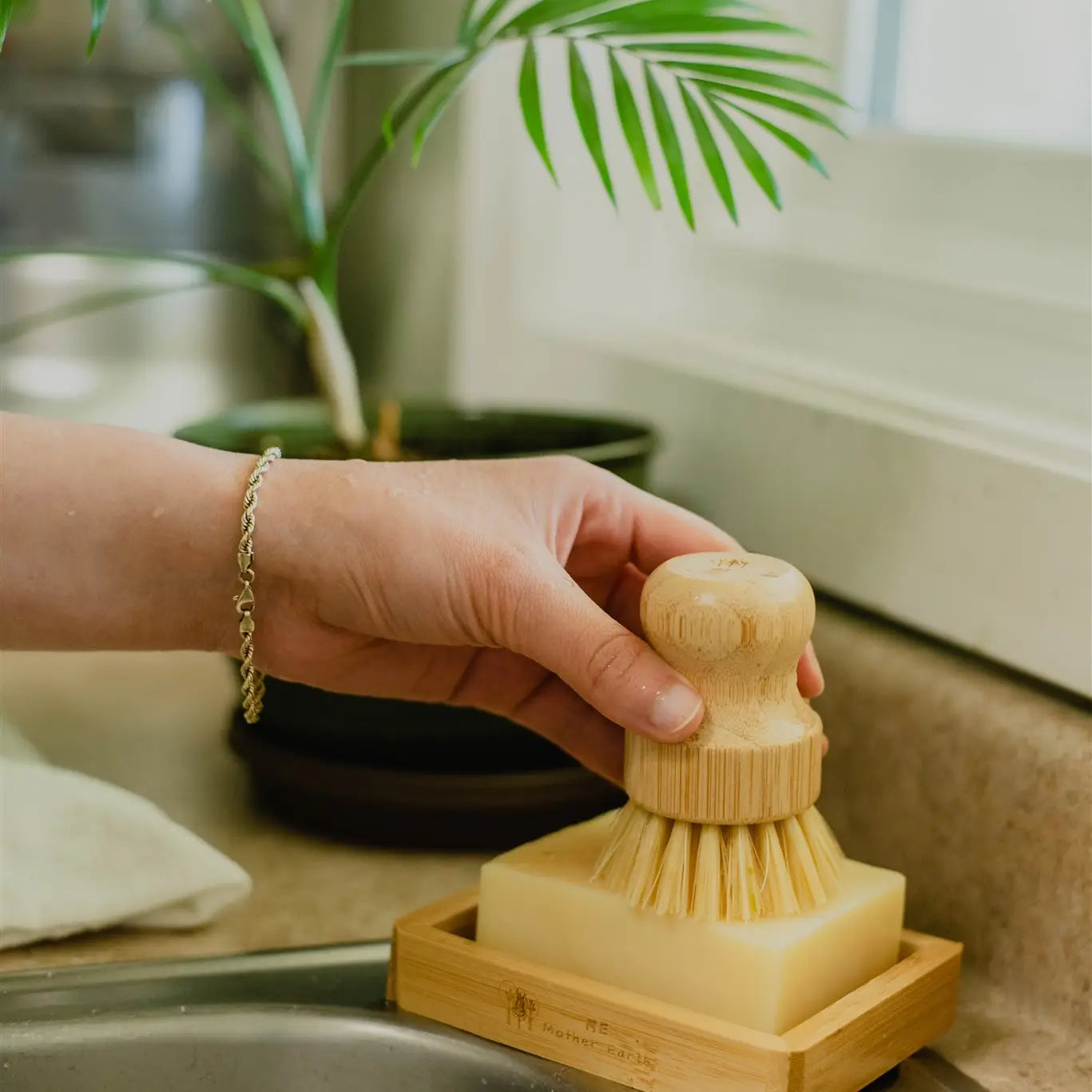 Woman holding ergonomic Sisal Brush with dish soap and soap dish