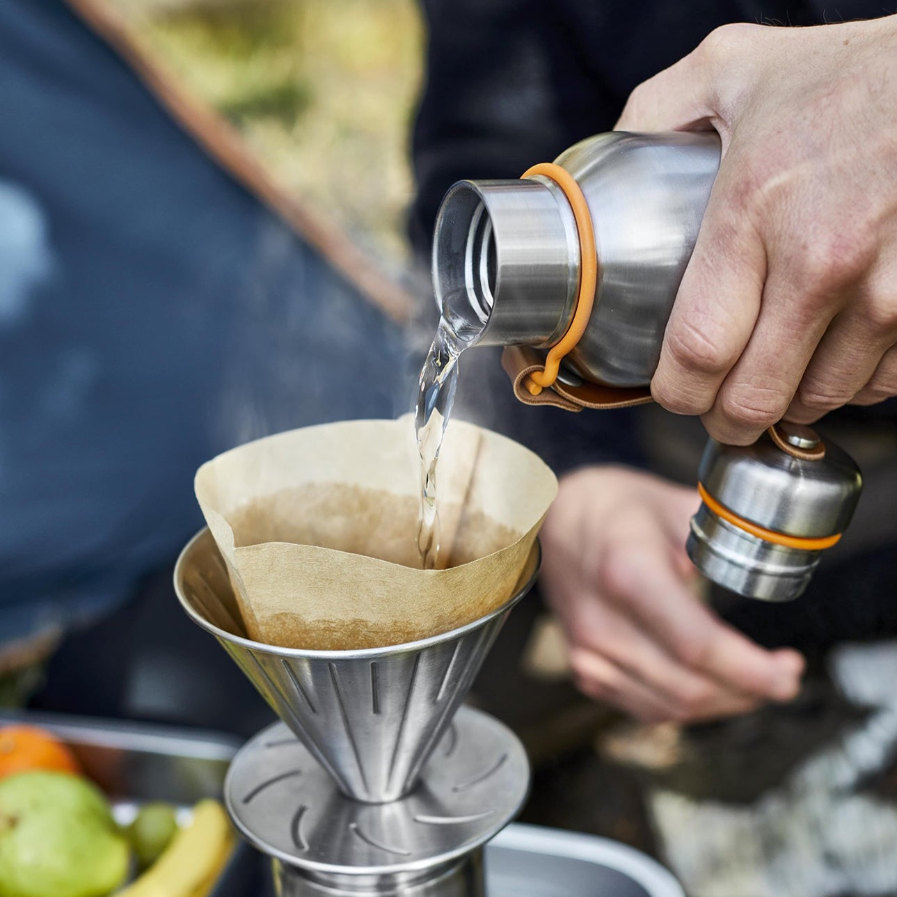 hot water being poured out of thermos to make coffee