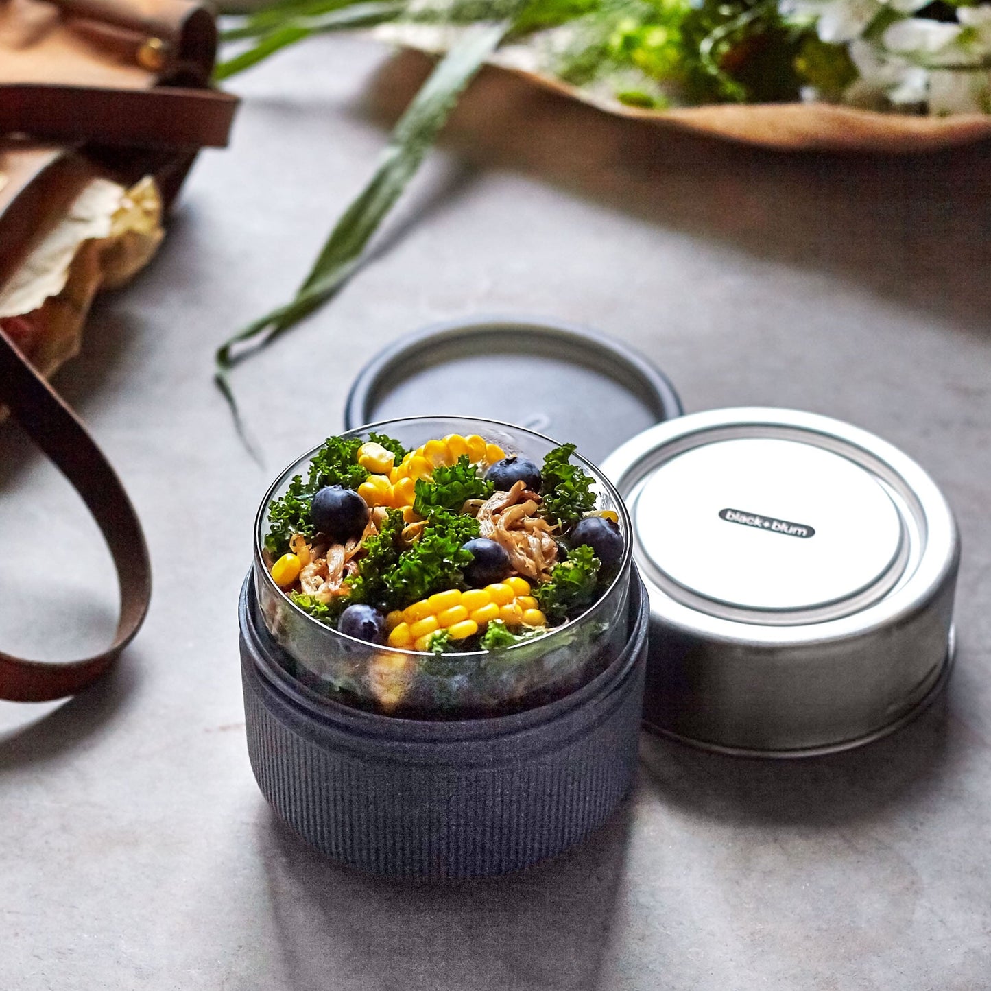 Kale and corn salad in a 20 oz glass lunch pot with slate wood fiber exterior and stainless steel lid.  100% leak proof.  microwave, freezer and dishwasher safe.
