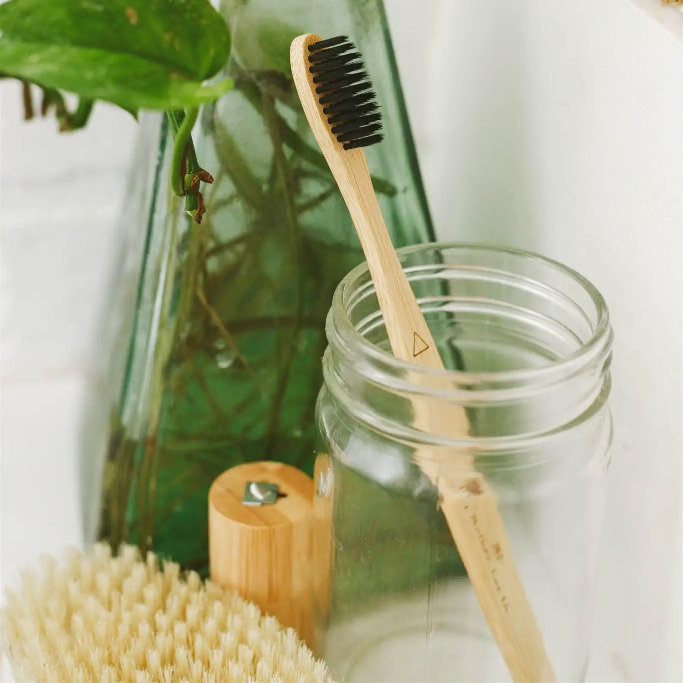 bamboo tooth brushes with active carbon bristles extra soft.  geometric shapes to tell them apart.  single brush in glass jar