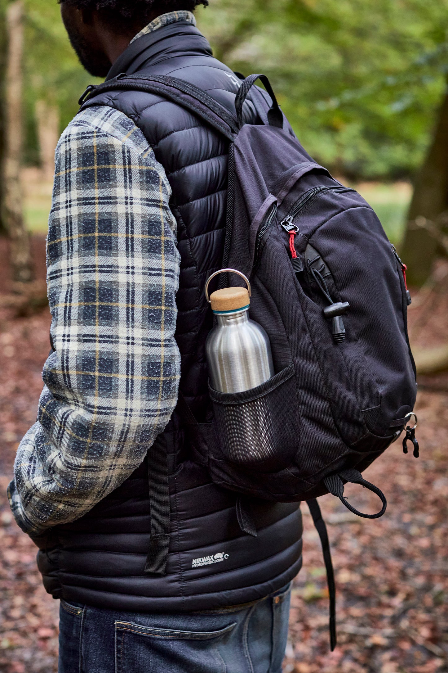 Steel water bottle in mans back pack hiking